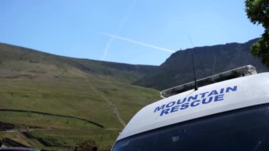 Dağ kurtarma kamyonu Birleşik Krallık 'ın Peak District ulusal parkına park etmiş durumda. Minibüsün ön camında dağ kurtarma işareti ve çatıda radyo vericisi antenleri var..
