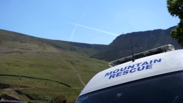 山岳救助サービストラックは ピーク地区国立公園 英国に駐車し 屋根のバンフロントウィンドウと無線送信アンテナの山の救助標識に焦点を当て ハンドヘルドショット — ストック動画