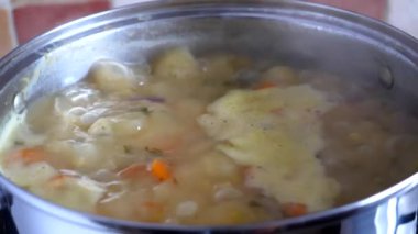 Yavaşça kaynayan sebze çorbası paslanmaz çelik tencerede yakın çekim; yavaş çekim.