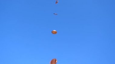 Birçok İngiliz 1 peni madeni parası mavi gökyüzü arka planına karşı ağır çekimde düşüyor.