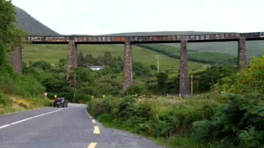 N70 'teki Gleensk Demiryolu Viaduct' u, Kerry Halkası turizm güzergahı, terk edilmiş ya da kapatılmış. Siyah araba kırmızı aracın geçmesine izin vermek için durur..