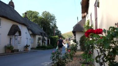 Yaşlı bir İngiliz köyünde el ele yürüyen genç bir çift.