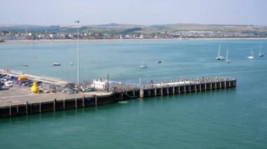 Weymouth Körfezi ve Liman 'ın görüntüsü. Güneşli yaz gününde uzak kasaba sahillerinde ve sığ körfez insanlarla dolu.. 