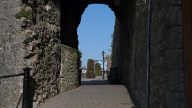Galler 'in Tenby kasabası. Tanımlanamayan insanlar güneşli bir günün tadını çıkarıyorlar, antik taş kemerlerinden bakıyorlar..