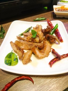 Kurutulmuş kavrulmuş biber ve kavrulmuş kaffir kireç yaprakları ile Derin Kızarmış Baharatlı domuz Boyun