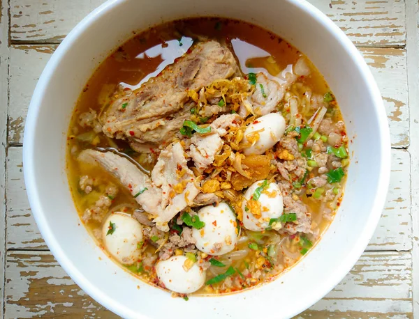 TOM YAM Pork Noodles Soup with Pork Balls, chilly pasted and lime juice / Noodles in Thai spicy tom yum soup with pork