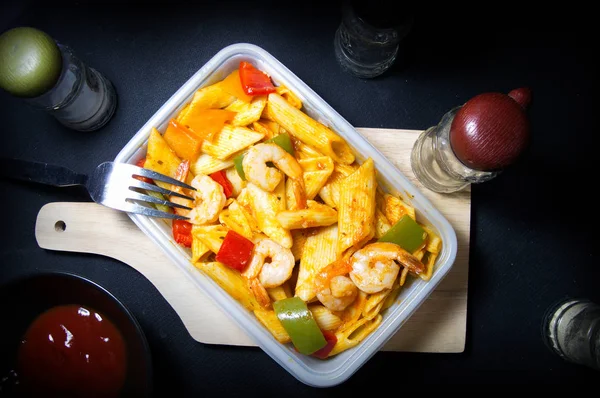 Penne makarna ile karides ve domates sosu ve dolmalık biber beyaz kutu içinde / üstten görünüm