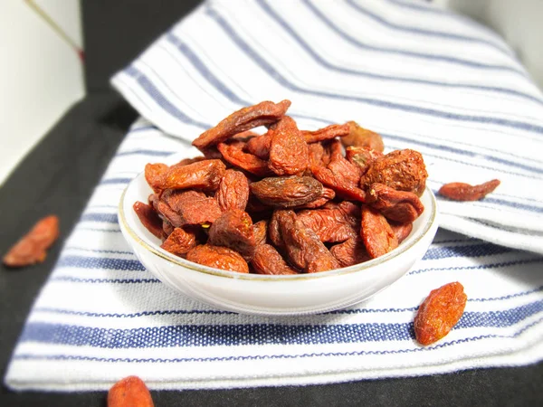 Yakın kadar Çin Wolfberry veya Goji Berry beyaz seramik küçük mutfak havlu izole tabak