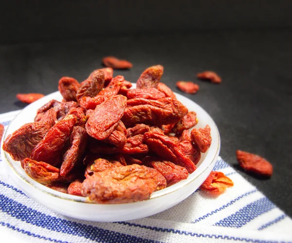 Yakın kadar Çin Wolfberry veya Goji Berry beyaz seramik küçük mutfak havlu izole tabak
