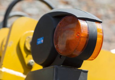Turuncu izni hafif sarı yol makine yakın çekim mekanizmaları, hidrolik hortumlar ve tuğla duvar arka plan bulanık ve uyarı
