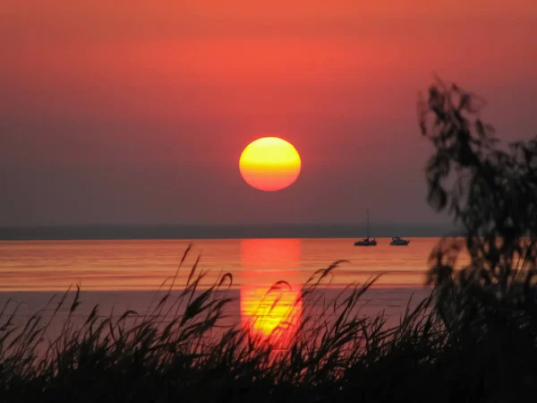 Bucht bei Sonnenuntergang mit Silhouetten von Jacht und Boot — Stockfoto