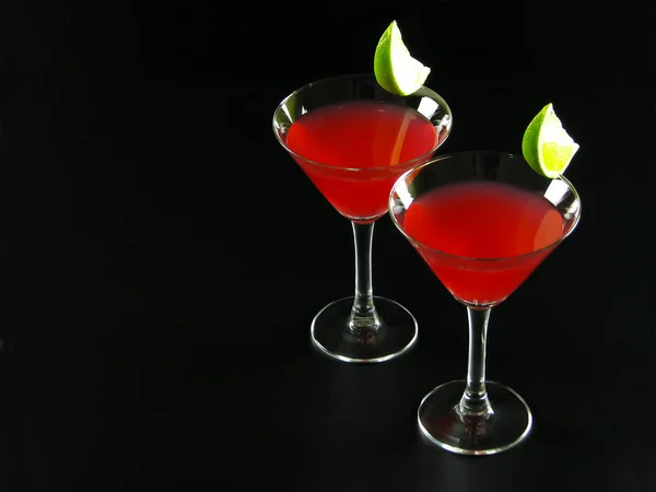 Deux cocktails Bacardi rouge vif, décorés de tranches de lime — Photo