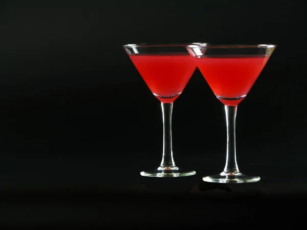 Cóctel Bacardi rojo brillante en dos copas de cóctel en un bac negro — Foto de Stock