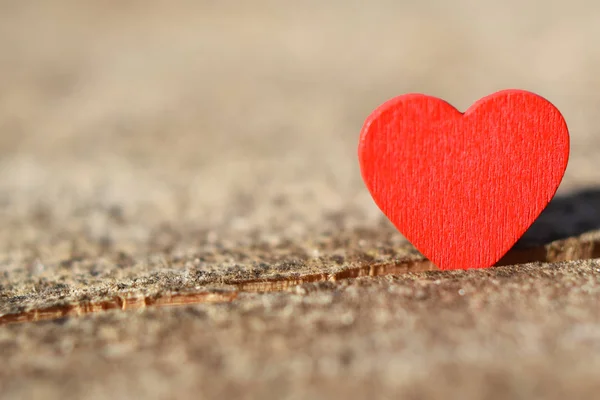 Red heart on light natural wood tree log background with copy space for text. Love and valentines day card and healthcare concept.