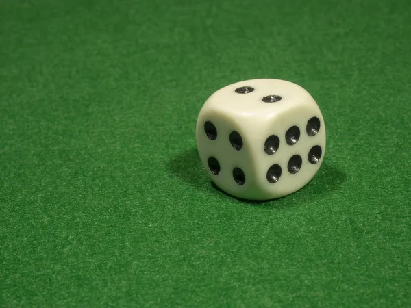 Kostní kostky bílé barvy s černými body pro gamblings leží na zelenou látkou. — Stock fotografie