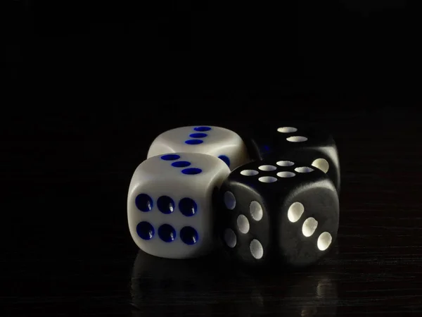 Jogo de mesa com dados à noite com luz fraca em um fundo escuro . — Fotografia de Stock