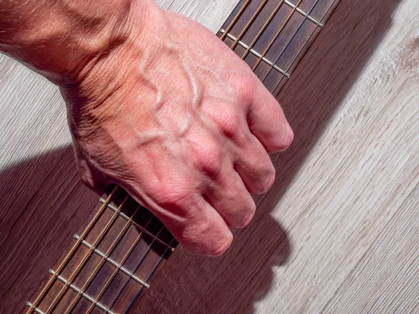 Bir rock müzisyeninin elinde akustik gitar.