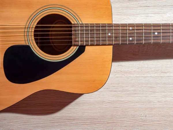Klasyczna gitara akustyczna brązowy na jasnym drewnianym tle — Zdjęcie stockowe