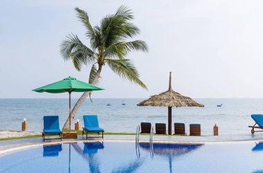 Havuz çevresindeki bir bahçede şezlonglar