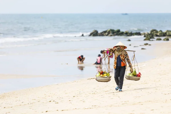 Vendedor de frutas y bebidas a pie en una playa en Nam Tien, Vietnam Fotos de stock