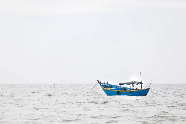 Fisher con un barco de pesca de madera en un mar en Nam Tien, Vietnam —  Fotos de Stock