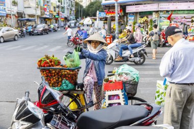 Vietnamlı kadın Saigon, Vie motosiklet üzerine meyve torbaları yükler