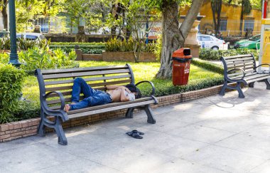 Adam Saygon, Vietnam kentinde bir park sandalyede uyuyor