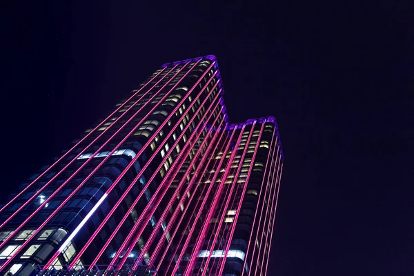 Skyscraper illuminated with colorful LED lights at night in Saig — Stock Photo, Image