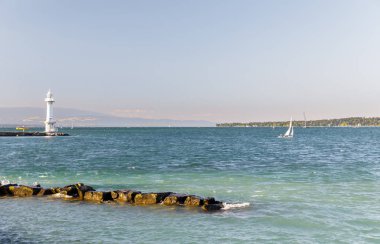 Arka planda kayalık iskele ve deniz feneri