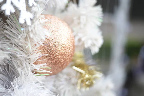 木の枝の抽象的な背景にメリー クリスマスと新年あけましておめでとうございますクリスマス ツリーと金のボール 白ボールのクローズ アップ — ストック写真