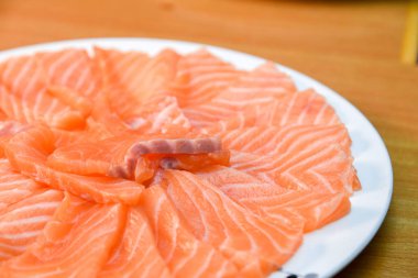 Ahşap blackground üzerinde beyaz tabak Slided çiğ somon