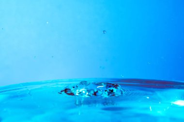 mavi su ve mavi arka plan düşen su damlası.