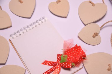 Kopya alanı ve beyaz blackground ahşap kalp şekli için boş not defteri üzerinde kırmızı gül. Sevgiliye arka plan. . düğün günü