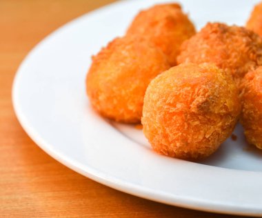 Peynir topları, ekmekli mozzarella peynir topları ahşap blackground üzerinde beyaz tabak domates ile