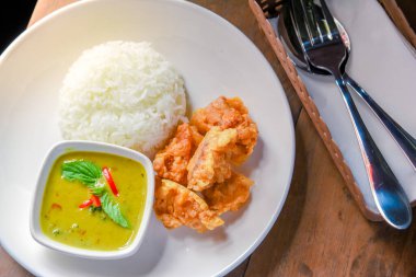 Kızarmış tavuk ve pirinçli yeşil köri, beyaz tabakta sebze. Tayland yemeği.