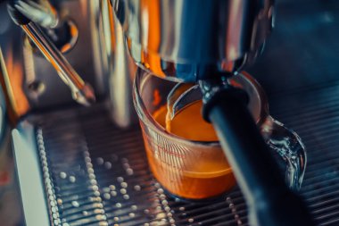 Barista, Americano shot kahve yapıyor, makine de bardağa, yakın plan.