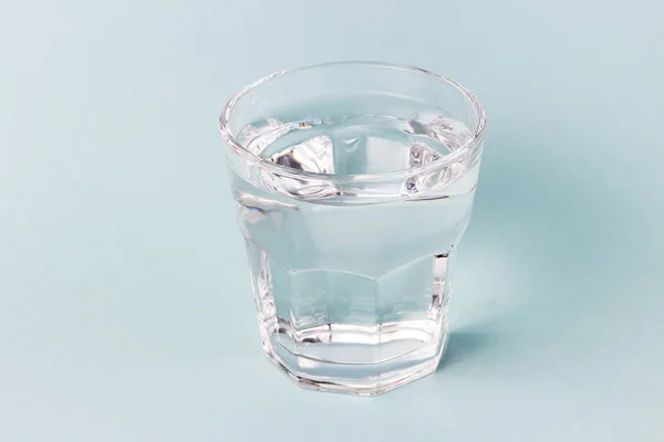 Стеклянная чашка с водой на синем фоне — стоковое фото