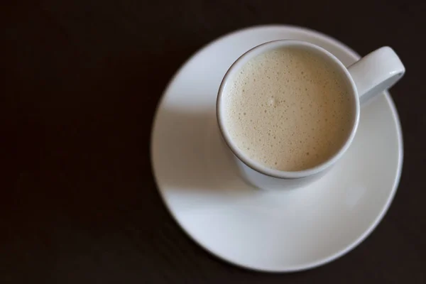 Eine Tasse Cappuccino auf einem braunen Tisch, Kopierraum — Stockfoto