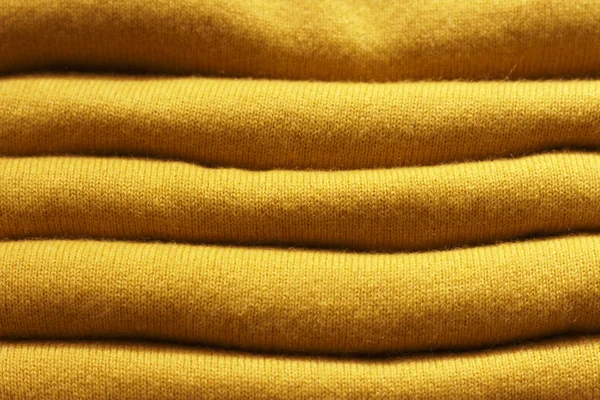 Stack of yellow woolen knitted sweaters close-up, texture, background — Stock Photo, Image