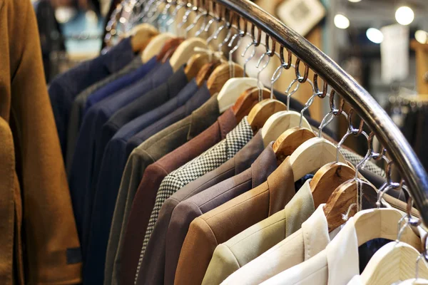 Стильные мужские куртки на вешалках в магазине, крупным планом — стоковое фото