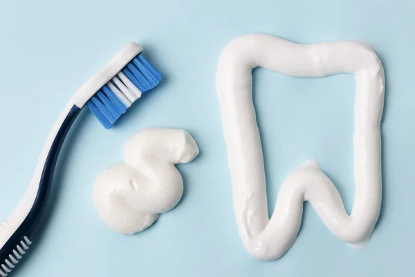 Pasta de dentes e escova de dentes em fundo azul. Conceito de higiene dentária . — Fotografia de Stock
