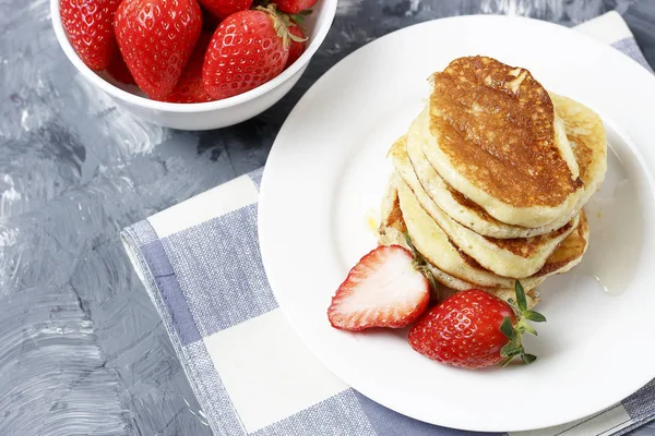 Pancakes on a plate and strawberries on a gray background — Stock Photo, Image