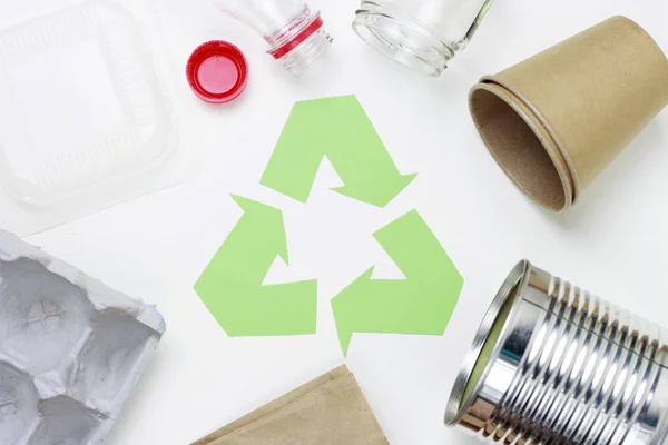 Verde reciclar basura símbolo y plástico, hierro basura sobre fondo blanco, vista superior . — Foto de Stock