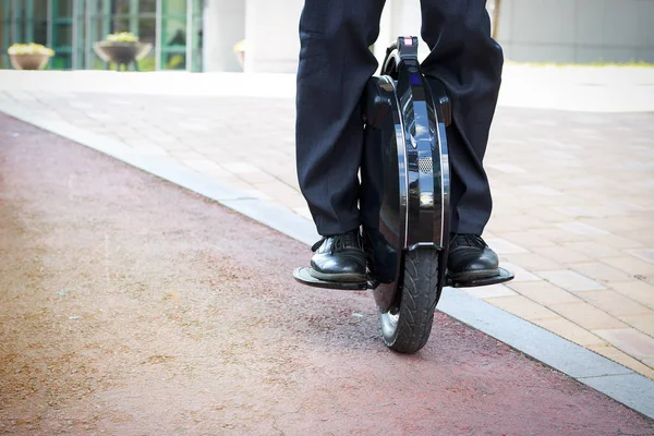 office worker is driving on an electric mono wheel, front view