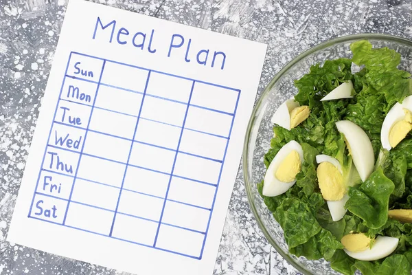 Inscription Meal Plan, schedule on white sheet, concept of weight loss. View from above