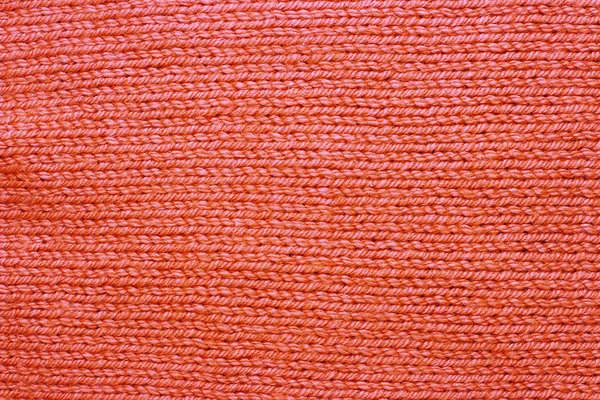 Knitted surface trend coral color close-up, fashionable background — Stock Photo, Image