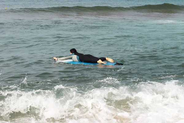 Dívka plachtící na moři na surfce, pohled zezadu — Stock fotografie