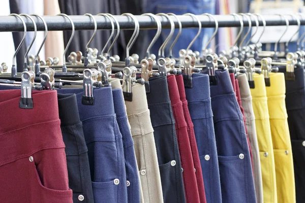 Разноцветные брюки, висящие на вешалке, вид сбоку — стоковое фото