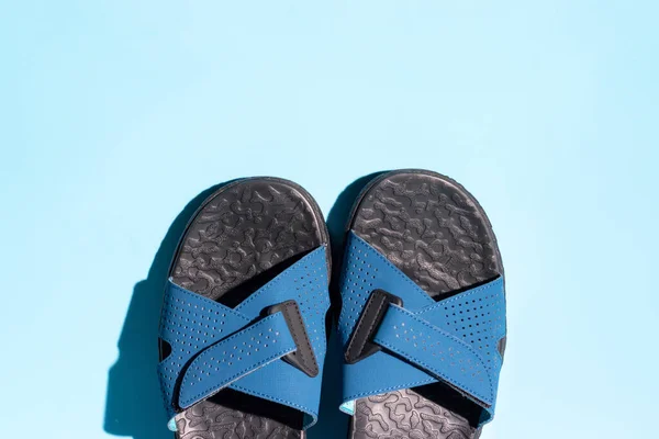 Une paire de sandales bleu foncé isolées sur fond bleu, vue d'en haut — Photo