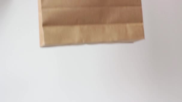Eldivendeki Kadın Eli Beyaz Arka Planda Kahverengi Karton Çanta Tutuyor — Stok video